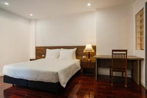 een slaapkamer met een bed, een bureau en een stoel bij ALEAH HOME in Hanoi