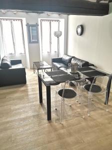 een woonkamer met 2 zwarte tafels en een bank bij Au Terminus 15 Personnes in Hautvillers +15 foto's