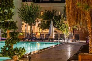 a pool with chairs and umbrellas in a building at Costa Maya Bodrum in Bodrum City