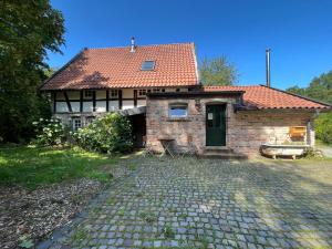 a brick house with a red roof and a driveway at grün in grün in Detmold