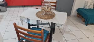 een glazen tafel met twee stoelen en een vaas erop bij Paradies Caraïbes III in Les Abymes