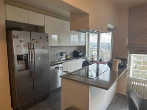 a kitchen with a refrigerator and a counter top at Clam，grand apartment in Uccle in Brussels