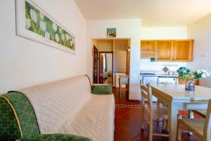 a living room and kitchen with a couch and a table at [PORTO CERVO] Accanto alla spiaggia & vista Mare in Porto Cervo