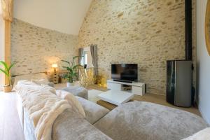 a living room with a couch and a tv at Lovely Bleau in Perthes-en-Gâtinais