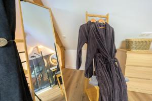 a robe hanging on a rack next to a mirror at Lovely Bleau in Perthes-en-Gâtinais