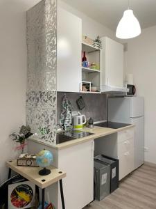 una pequeña cocina con armarios blancos y una mesa en Nuova Casa di Mattia Bologna en Bolonia