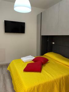 Una cama amarilla con una manta roja. en Nuova Casa di Mattia Bologna en Bolonia