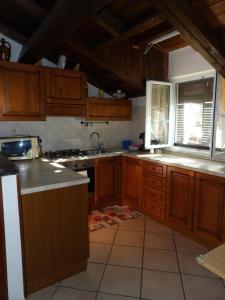 cocina con armarios de madera, fregadero y ventana en Gala, en Casarza Ligure