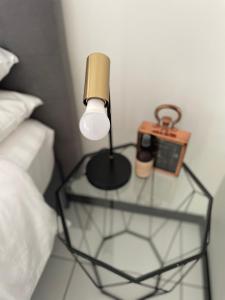 una lámpara en una mesa de cristal junto a una cama en Fourways Luxe Suite en Sandton