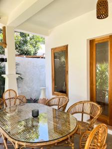 a dining room with a glass table and chairs at Casa Flores in Kuta Lombok