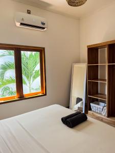 Schlafzimmer mit einem Bett und einem Fenster in der Unterkunft Casa Flores in Kuta Lombok