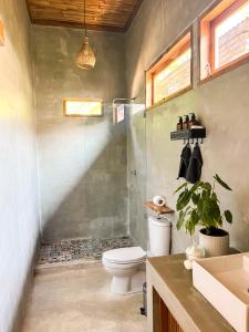 ein Bad mit einer Dusche, einem WC und einem Waschbecken in der Unterkunft Casa Flores in Kuta Lombok