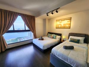 1 dormitorio con 2 camas y ventana grande en Loft Suite Seaview near JB CIQ 8pax en Johor Bahru