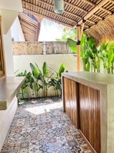 an outdoor patio with a tile floor and a bar at Casa Flores in Kuta Lombok