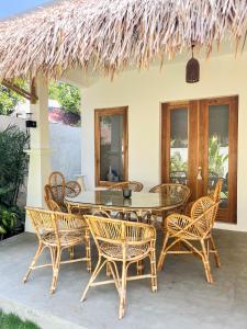 ein Holztisch und Stühle auf einer Terrasse in der Unterkunft Las Flores Lombok in Kuta Lombok + 27 Fotos