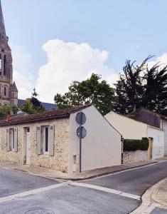 un vieux bâtiment sur le côté d'une rue dans l'établissement La Maison de Jeanne, à Lesparre-Médoc