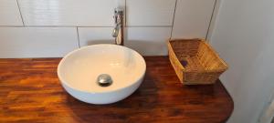 a bathroom with a white sink and a basket at Paradies Caraïbes III in Les Abymes +3 photos