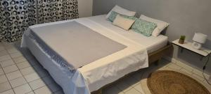 a large bed in a small room with at Paradies Caraïbes I in Les Abymes