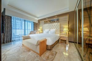 a bedroom with a bed and a couch and a window at Nanning Landmark Hotel in Nanning