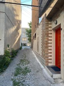 an alley between two buildings with a red door at Appartment in the city center in Gyumri