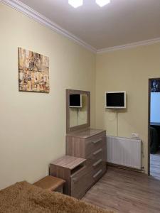 a bedroom with a dresser with a mirror and a dresser with a tv at Appartment in the city center in Gyumri