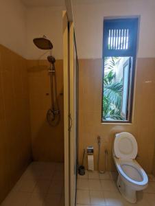 a bathroom with a toilet and a window at Culture Hub Backpack Hostel in Sri Jayewardenepura Kotte