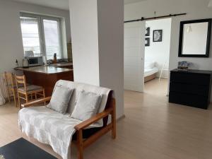 a living room with a couch and a desk and a kitchen at Apartament Parion 2 in Lublin