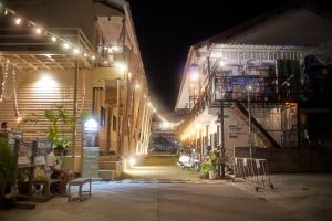 a man sitting at a table outside of a building at night at U Hostel Koh Phangan in Haad Rin