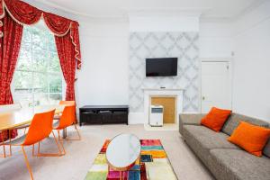 een woonkamer met een bank en een tafel bij Larger Groups Apartment close to Excel CanaryWharf 02 with Parking in Londen