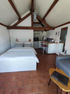 a bedroom with a bed and a couch and a table at Les bourrines du marais, Le bourrineau in Sallertaine
