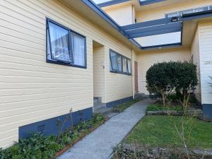 una casa con una ventana en un lado en The Cozy Hutt Home, en Upper Hutt