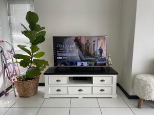 uma cómoda branca com uma televisão por cima em Fourways Luxe Suite em Sandton