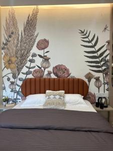 een slaapkamer met een bed met bloemen aan de muur bij Cozy Studio with Premium Interiors-WiFi,AC,SmartTv in Pune
