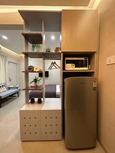 een keuken met een koelkast en een magnetron bij Cozy Studio with Premium Interiors-WiFi,AC,SmartTv in Pune