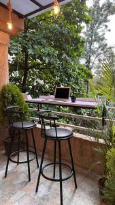 een patio met 2 stoelen en een tafel met een laptop bij Cozy Studio with Premium Interiors-WiFi,AC,SmartTv in Pune