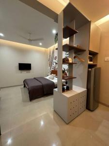 a bedroom with a bed and a television in a room at Cozy Studio with Premium Interiors-WiFi,AC,SmartTv in Pune