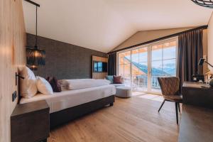 Cette chambre comprend un lit et une grande fenêtre. dans l'établissement Hotel Fernblick Montafon, à Bartholomäberg