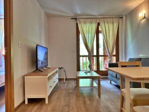ein Wohnzimmer mit einem TV auf einer Kommode mit einem Tisch in der Unterkunft Pleta de Soldeu 345 hasta 4 personas. in Canillo
