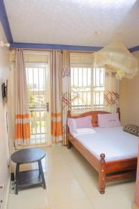 1 dormitorio con cama y ventana en Perfect Motel en Kampala
