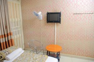Habitación con cama y TV en la pared. en Perfect Motel en Kampala