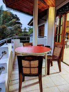 einen Tisch und Stühle auf einem Balkon mit einem Tisch in der Unterkunft Moon Water's Edge in Kandy