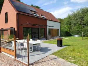 una casa con patio y mesa en el patio en Moere Dijk, en Koekelare