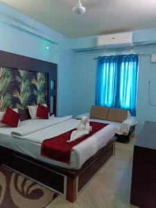 een slaapkamer met een groot bed met een knuffeldier erop bij Hotel Nirmala Inn in Jamūi