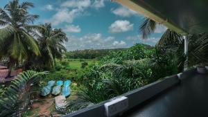 a view of a jungle with palm trees and blue chairs at SortBy Stays, Anjuna in Anjuna