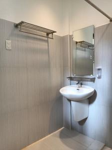 uma casa de banho com um lavatório e um espelho em Vivo Siargao em General Luna