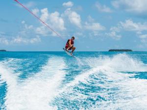 un hombre esquiando en el agua con una cuerda en Angsana Velavaru - All inclusive SELECT, en Dhaalu Atoll