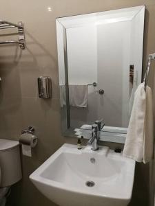 uma casa de banho com um lavatório branco e um espelho. em ***Panglao 2BR Villa w/Private Pool Near the Beach em Taporok