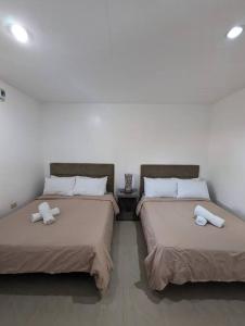 duas camas sentadas uma ao lado da outra num quarto em ***Panglao 2BR Villa w/Private Pool Near the Beach em Taporok