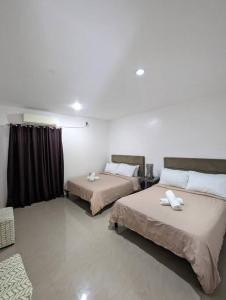 um quarto com duas camas com toalhas em ***Panglao 2BR Villa w/Private Pool Near the Beach em Taporok