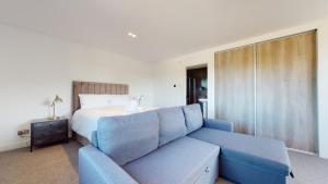 a bedroom with a blue couch and a bed at Low Greenlands Holiday Park - Luxury House & Luxury Glamping Pods in Lancaster